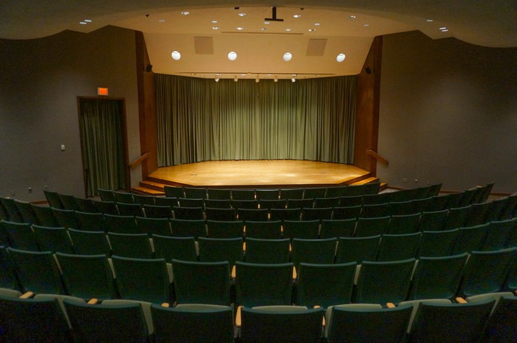 A lit stage inside of a small theater venue