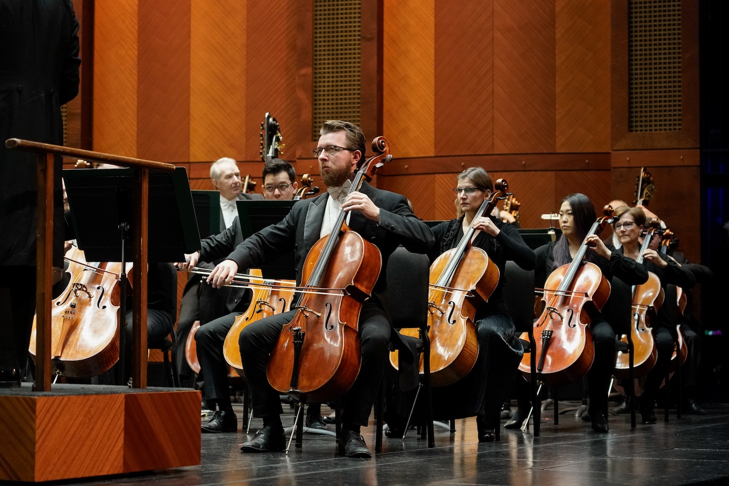 orchestra cello section seated on stage
