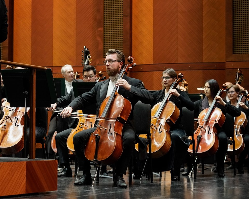 orchestra cello section seated on stage
