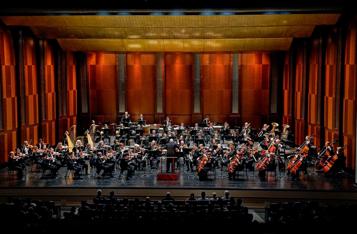 Fort Worth Symphony Orchestra taking bows with audience standing in cheer