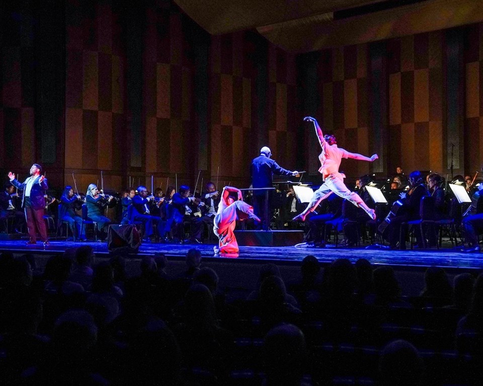 Two black female dancers sharing the stage with an orchestra and black male soloist