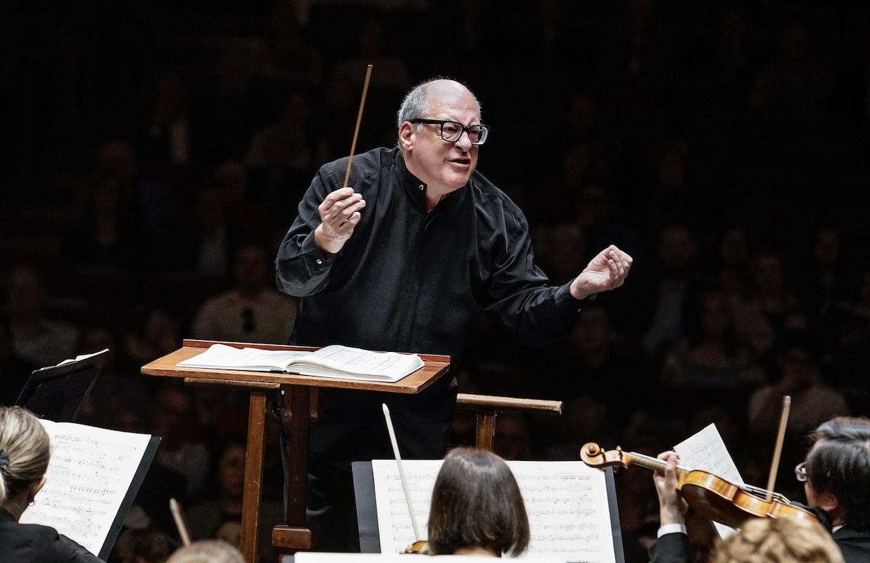 conductor in all black dress with glasses during concert