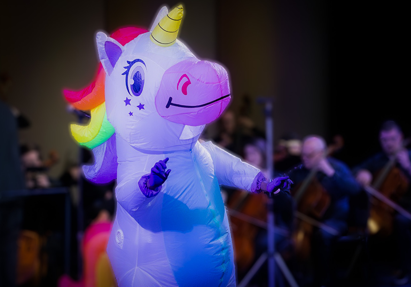 Inflatable rainbow unicorn in front of orchestra